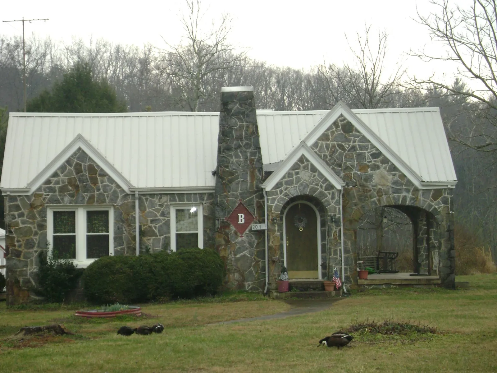 White metal roof on a stone cottage with steep gables in Westfield